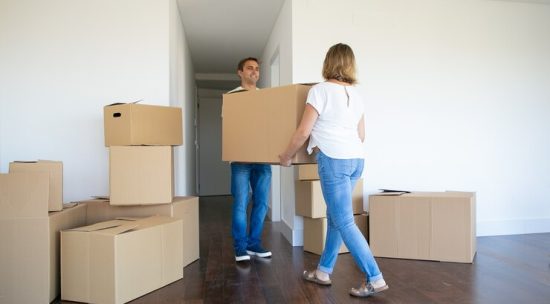 married-couple-leaving-apartment-carrying-cartoon-box-entrance-together_74855-10260